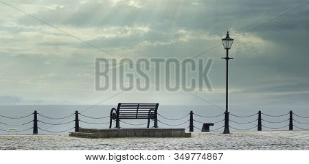 Lonely Empty Bench Seat During Coastal Sea Storm At Greenock Scotland