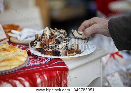 Shallow Depth Of Field (selective Focus) Image With A Man Taking A Piece Of Cozonac, Romanian Tradit