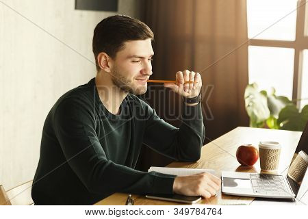 Happy Office Worker. Cheerful Guy At Laptop Browsing Internet Sitting At Work Desk Indoors. Selectiv