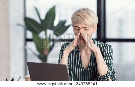 Sick At Work. Business Woman Touching Nosebridge Having Sinus Pain Sitting At Workplace Indoors. Sel