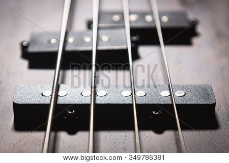 Bass Electric Guitar With Four Strings Closeup. Detail Of Popular Rock Musical Instrument. Close Vie