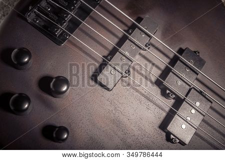 Bass Electric Guitar With Four Strings Closeup. Detail Of Popular Rock Musical Instrument. Close Vie