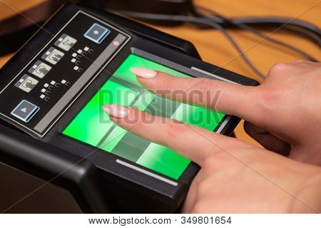 The Process Of Scanning Fingerprints During The Check At Border Crossing. Female Hand Puts Fingers T