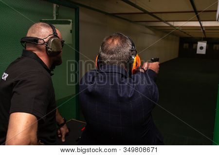 Shooting In The Dash Of Short-barreled Weapons. A Man Aims At A Target Before Firing A Pistol. The I