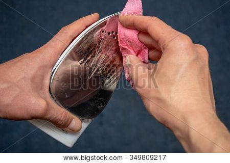 Removal Of Melted Fibers And Scrap Hardened Plastic On The Soleplate. Cleaning The Surface Of The Ir