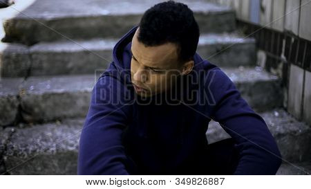 Aggressive Bully Sitting On Steps, Waiting For Victim To Rob, Planning Crime