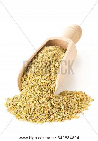 Heap Of Uncooked, Raw Freekeh Or Firik, Roasted Wheat Grain, In Wooden Scoop Over White Background