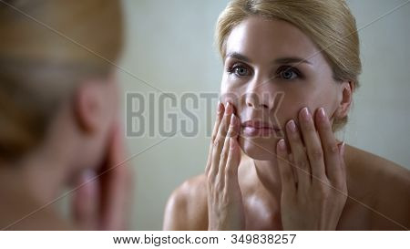 Disappointed Woman Looking At Face Reflection In Mirror, Anti-aging Injections