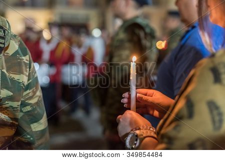 Closeup Of People Holding Candle At Night During Church Service