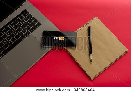 Tula, Russia - February 07, 2020: Logo Porn Hub On A Smartphone Near Modern Laptop On Red Background
