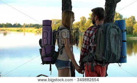 Boyfriend With Lady Watching River Scape, Holding Field Flowers, Green Tourism