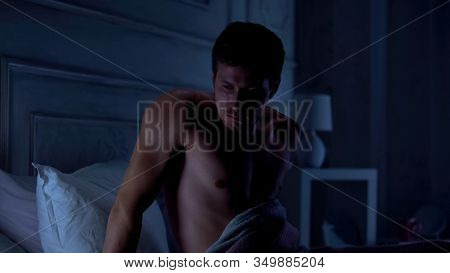 Young Male Waking Up At Night, Suffering Post-traumatic Syndrome, Nightmare