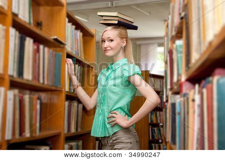 Niña sostiene un libro en la cabeza