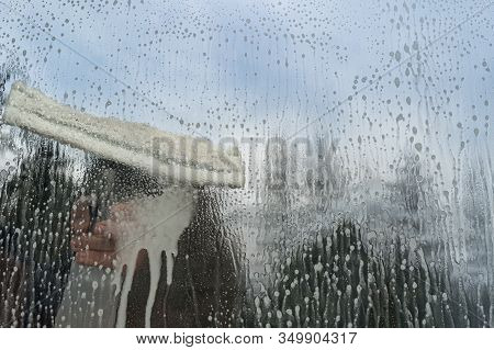Caucasian Man Washing Glass With Microfiber Window Washer. Spring Cleaning Concept. Blue Sky.