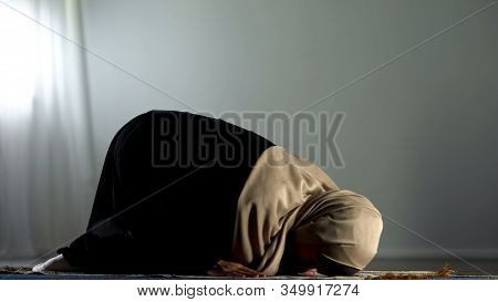 Kneeling Arab Woman Prostrating On Islamic Praying Rug, Religious Worship, Faith