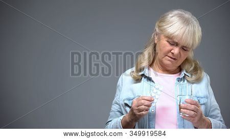 Unhappy Aged Lady Holding Pills Unwilling To Take Them, Ineffective Medication