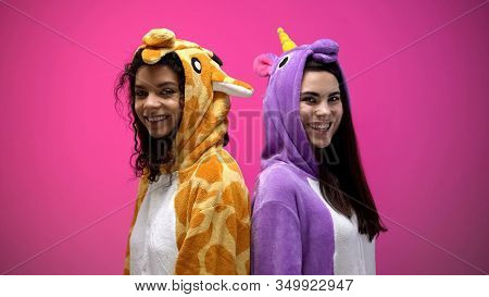 Interracial Friends In Unicorn And Giraffe Costumes Standing Back To Back, Smile