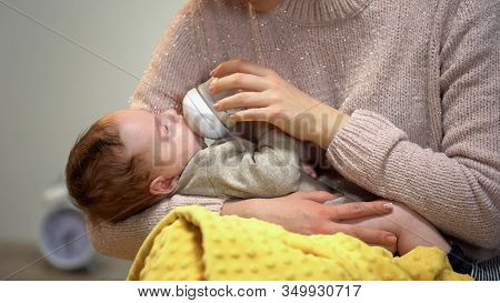 Mommy Feeding Little Cute Baby From Bottle, Tenderly Holding Son, Love And Care