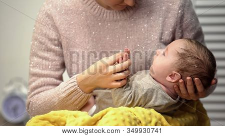 Mother Holding Baby Boy In Arms And Playing With Him, Early Infant Development