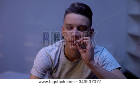 Male Teenager Smoking Weed Joint, Evening At Home, Awkward Age Experiment
