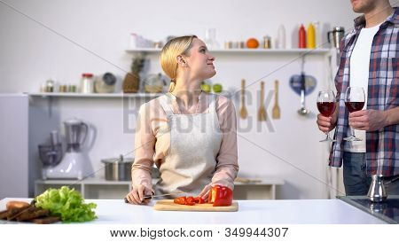 Beautiful Young Wife Cooking Salad, Husband Bringing Wine To Relax, Romance