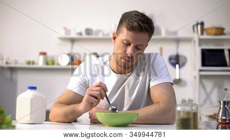 Unhappy Lonely Man Looking With Disgust At Food In Bowl, Lack Of Appetite