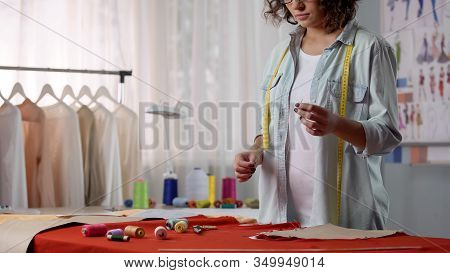 Seamstress Putting Thread In Needle, Starting To Sew Parts Of Clothes Together