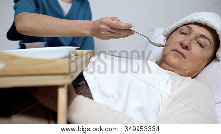 Terminally Ill Woman With Compress On Forehead Refusing From Hospice Porridge