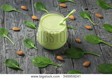 Glass Glass With Avocado Drink On A Background Of Spinach Leaves And Almonds. Fitness Product. Dieta