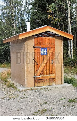 A Roadside Outhouse With The Sign Upside Down