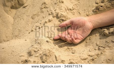 Male Hand Lying Lifeless On Sand, Death Of Thirst In Sahara, Lack Of Water