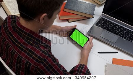 Male Kid Holding Smartphone With Green Screen, Reading Online Post, Gadget App