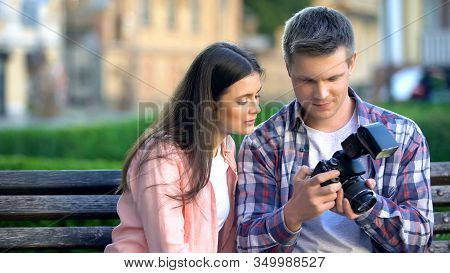 Unexperienced Female Photographer Asking Colleague For Help With Camera Settings