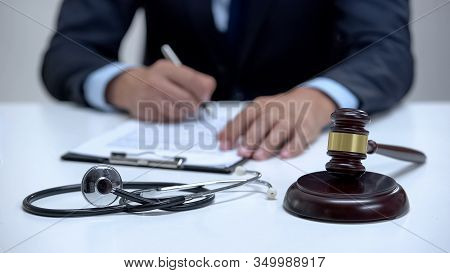 Judge Signing Arrest Warrant For Medical Error, Banging Gavel Near Stethoscope