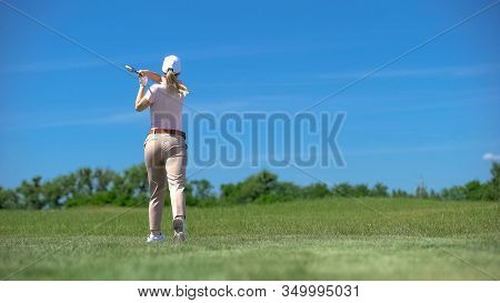 Skilled Female Golfer Hitting Ball In Backswing Position, Training And Hobby