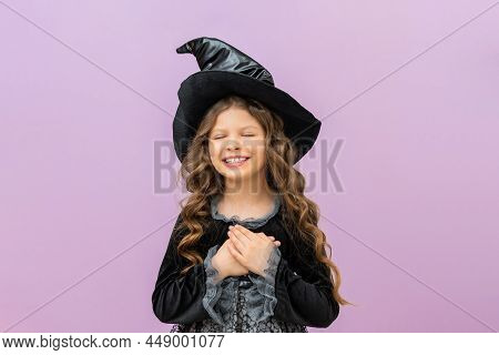 A Surprised Witch In A Magical Costume On An Isolated Background. A Joyful Sorceress In A Magician's