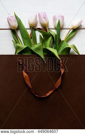 Spring Bouquet Of Pink Tulips In Brown Paper Bag On Wooden Background