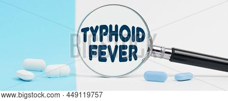 Medicine And Health Concept. On A Blue And White Background, There Are Pills And A Magnifying Glass,