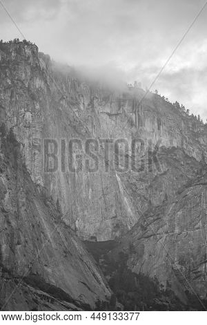 A Dramatic Up Close Mountain Scape Image. The Peak Of The Mountain Is Being Taken Over By Rain Cloud