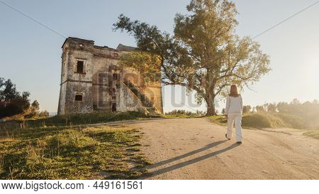 Beautiful Girl In White Dress Enters An Ancient Castle In The Countryside From The Main Staircase. W