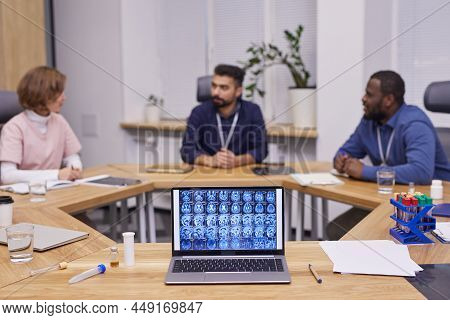 Brain Scan On Laptop Screen On Background Of Three Young Intercultural Medical Experts Brainstorming
