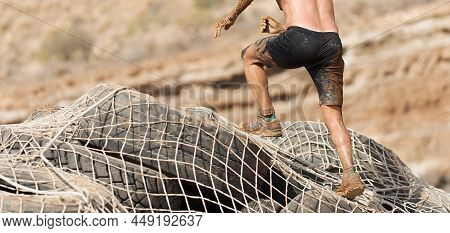 Mud Race Runners.the Participante Overcoming The Obstacle Made Of Tires