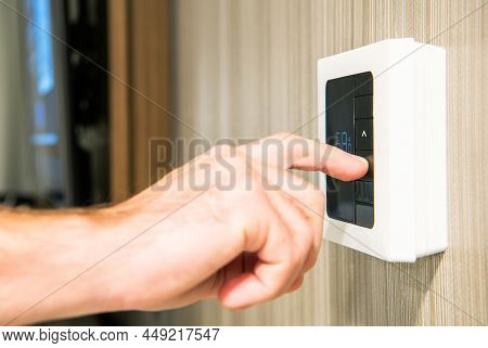 Caucasian Men Setting Residential Modern Wall Thermostat To Lower Temperature To Save Energy During 