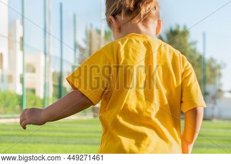 Faceless Little Girl In Yellow T-shirt Playing Football.