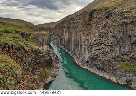 Studlagil Canyon In Iceland, View At The River And The Basalt Columns