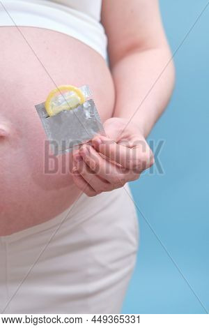 Pregnant Woman With A Condom On The Background Of Her Stomach