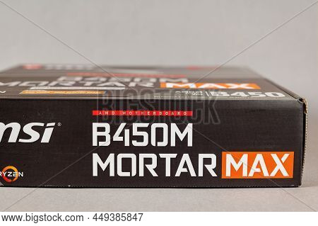 Msi B450 Mortal Max Motherboard Against A Gray Background. Black Box With The New Computer Hardware.
