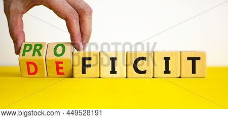 Proficit Or Deficit Symbol. Businessman Turns Cubes, Changes The Word Deficit To Proficit. Beautiful