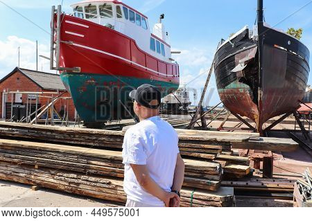 Port Of Hundested On A Beautiful Sunny Summer Day. Old Boat Under Repair To The Shipyard. Small Dani