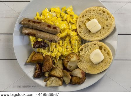 Scrambled Eggs Served With Sausage , Homefries And English Muffins